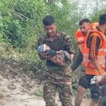 Army Personnel Saving a Child