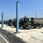 Army Trucks Along Freight Train